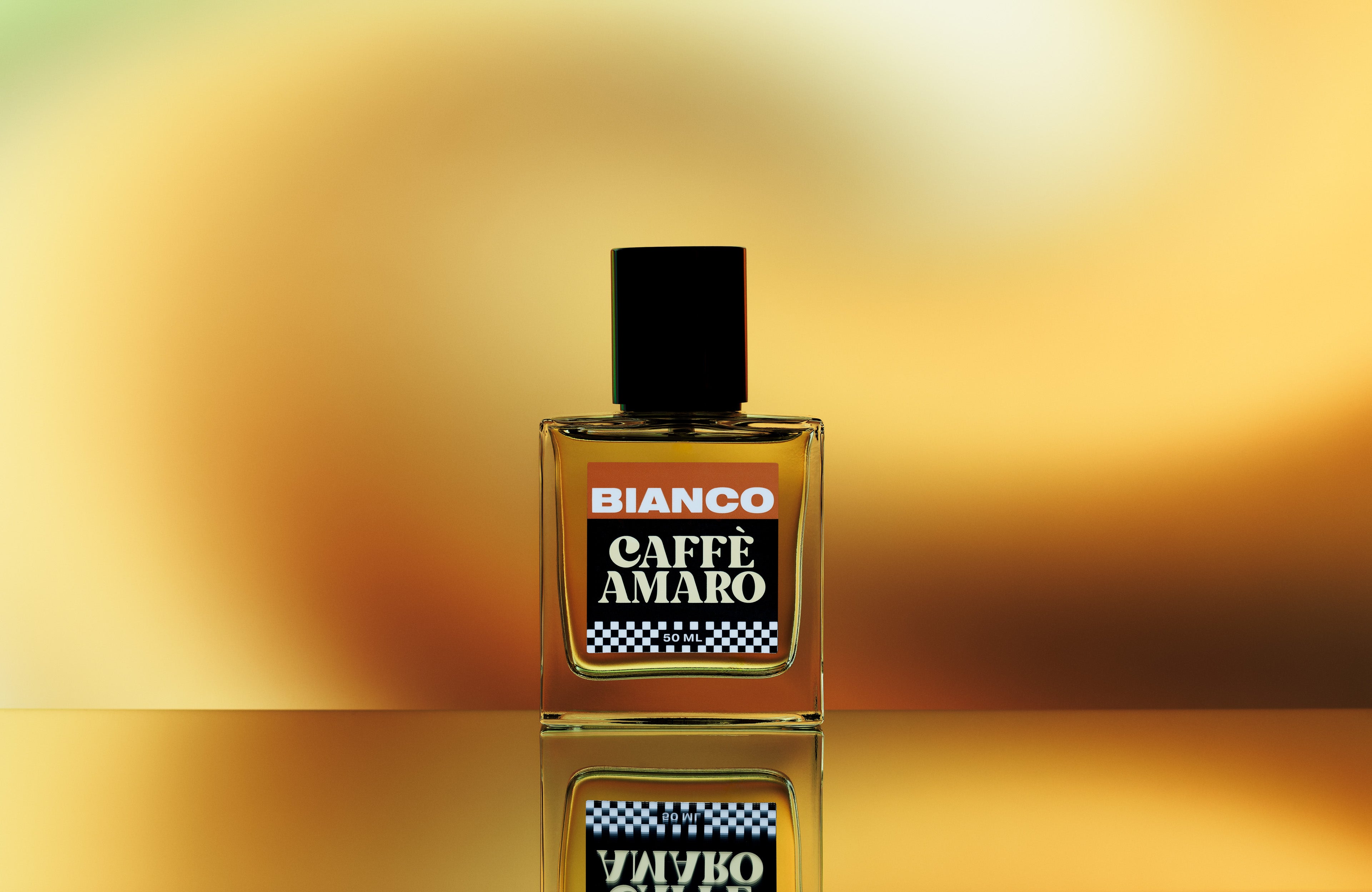 Bottle of Bianco Caffè Amaro on a reflective surface with a gradient gold background